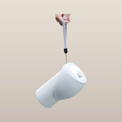 MoonRise 550ml white silicone portable water bottle with a grey carry strap, held by hand against a neutral background.