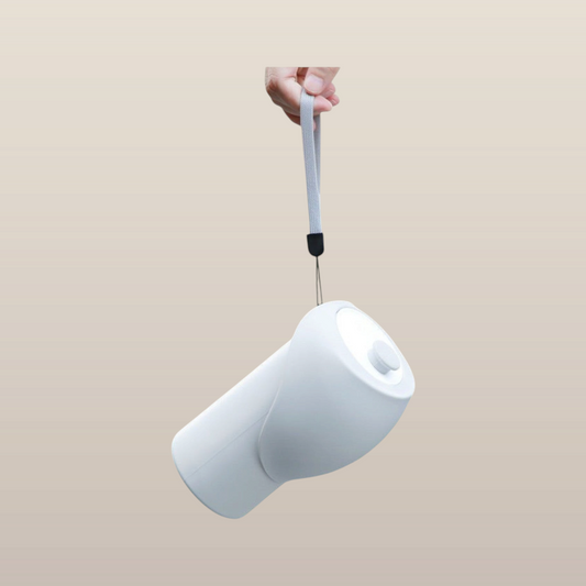 MoonRise 550ml white silicone portable water bottle with a grey carry strap, held by hand against a neutral background.